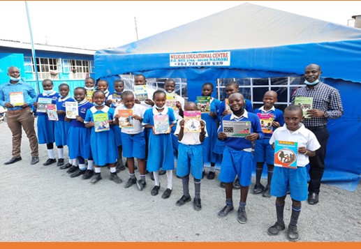 Welicar school children holding up books donated